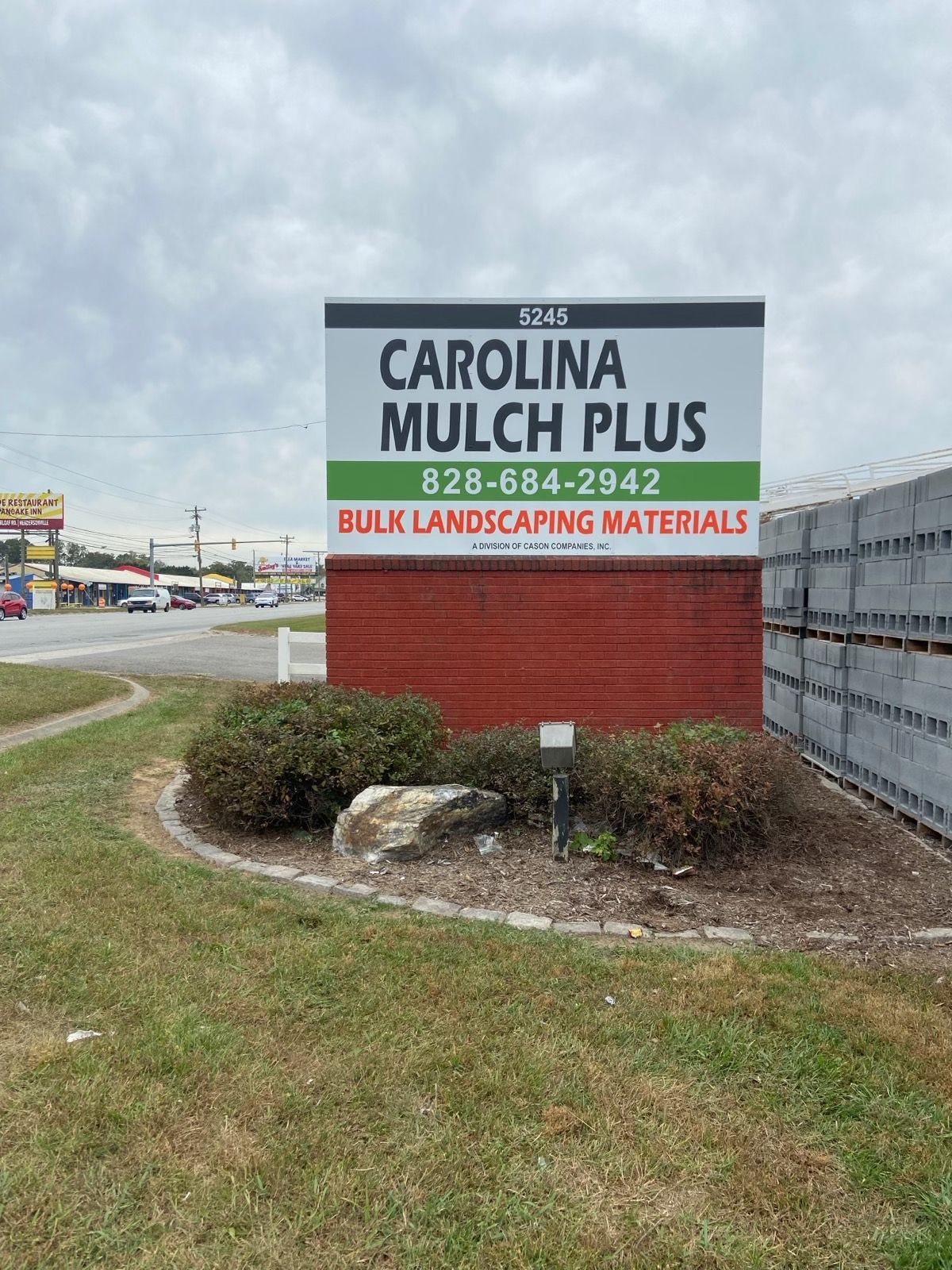 Sign for Carolina Mulch Plus, a bulk landscaping materials supplier, with a red and white background, phone number, and address.