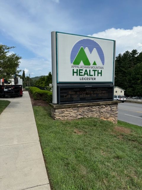 Sign for Appalachian Mountain Health in Leicester, with green mountains and blue sky logo on a white background.  A digital display board is below.