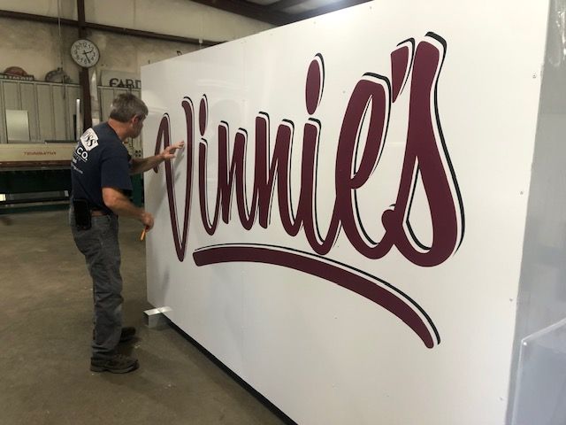 A man applies a large, maroon 