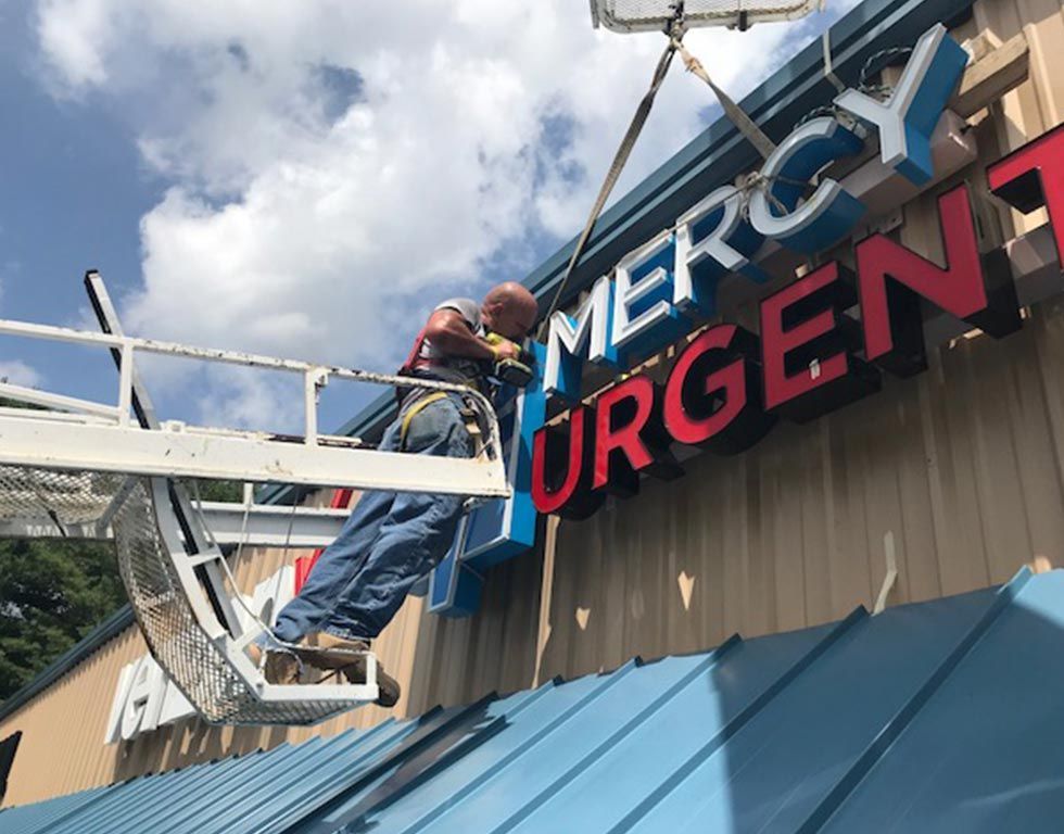 Man in a lift installs a blue and red 
