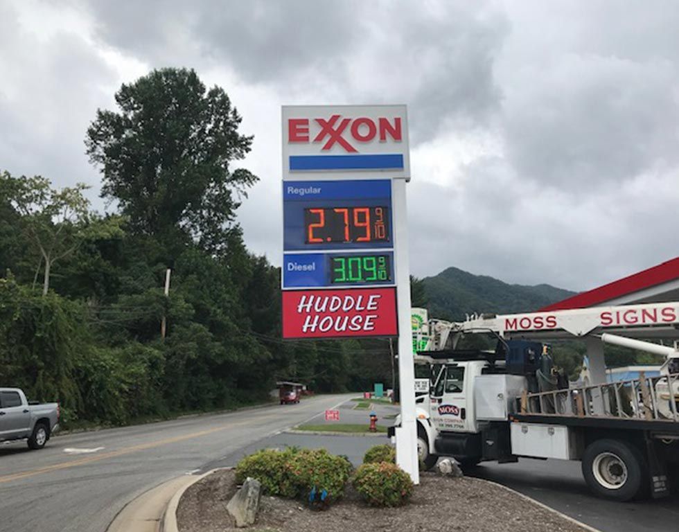Gas station sign with Exxon logo displaying gasoline at $2.79 and diesel at $3.09, Huddle House below, roadside location.
