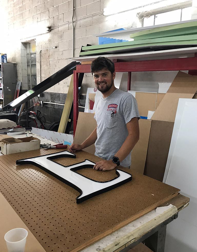 A man smiling at the camera, standing next to a large black and white 