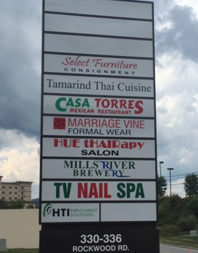 Sign with business names: Select Furniture, Thai Cuisine, Mexican Restaurant, formal wear, hair salon, brewery, nail spa, employment solutions; on Rockwood Rd.