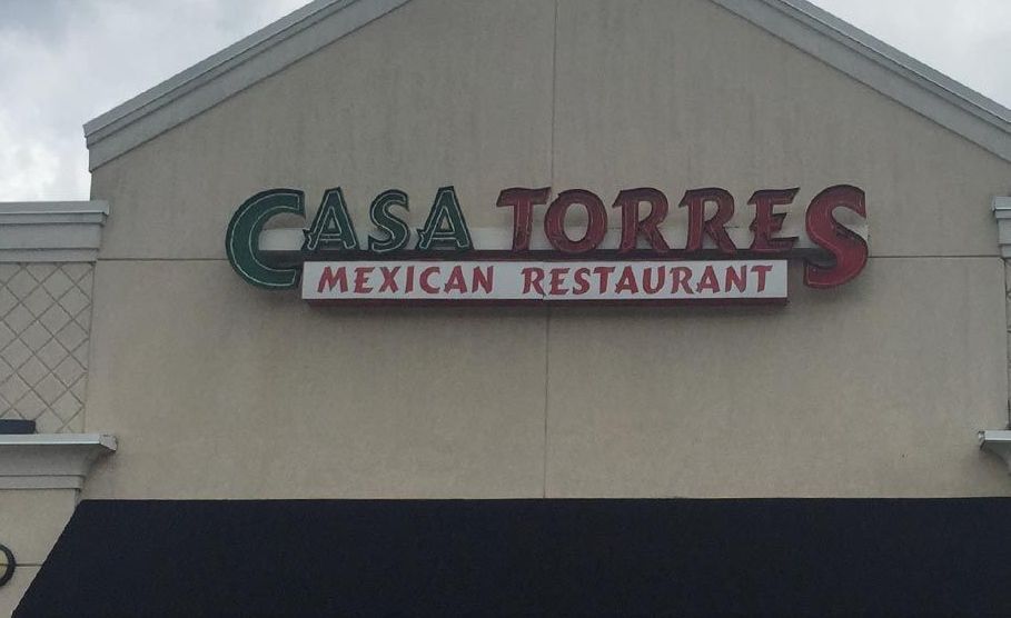 Casa Torres Mexican Restaurant sign with green and red lettering on a beige building.