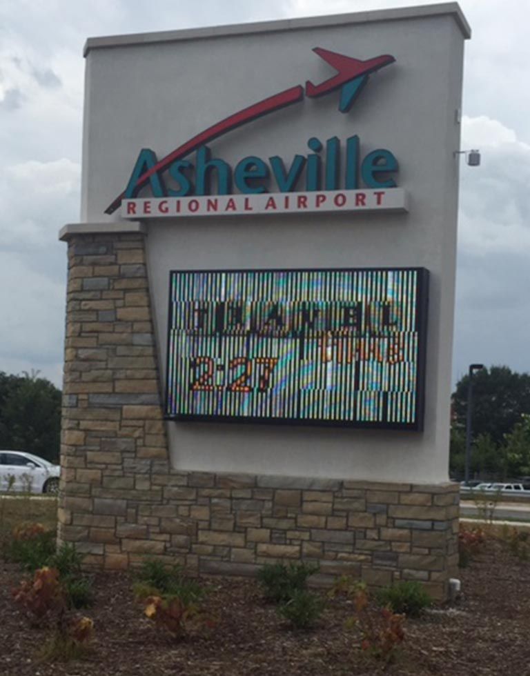 Asheville Regional Airport sign with a digital display showing a flight status.