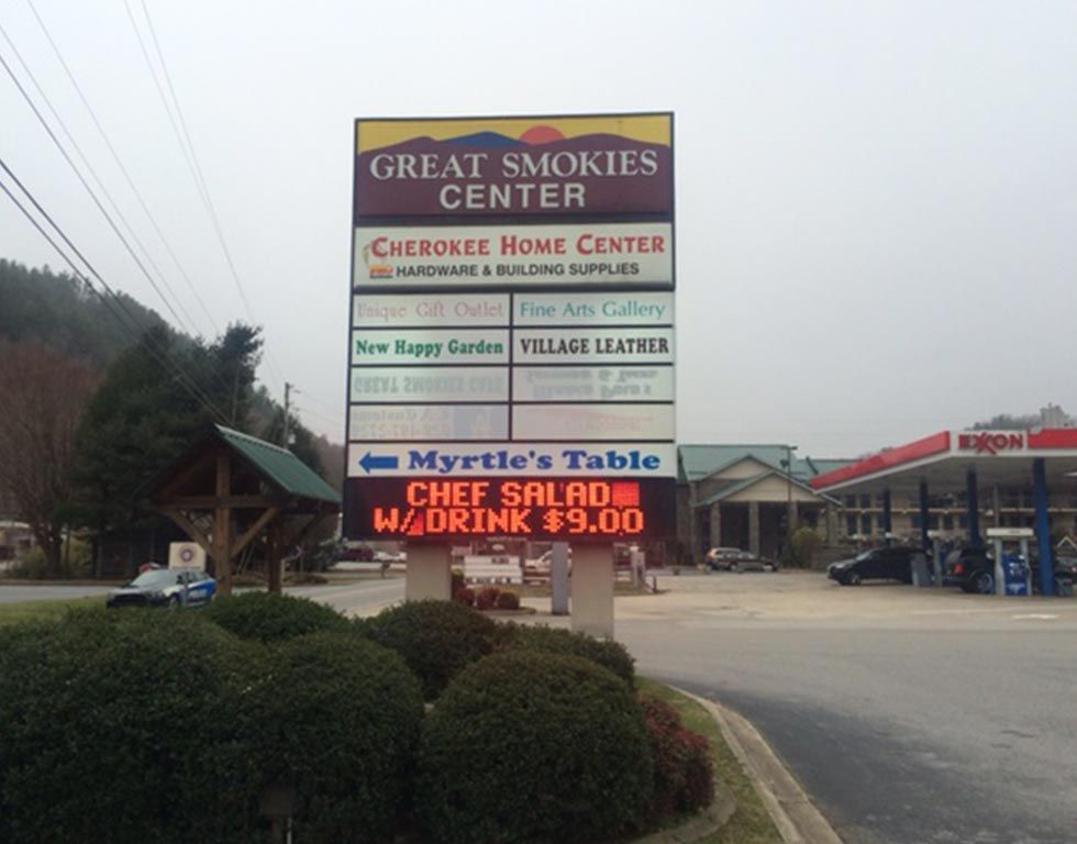 Sign at the Great Smokies Center with store names and a digital display for Myrtle's Table, advertising a chef salad with drink for $9.00.