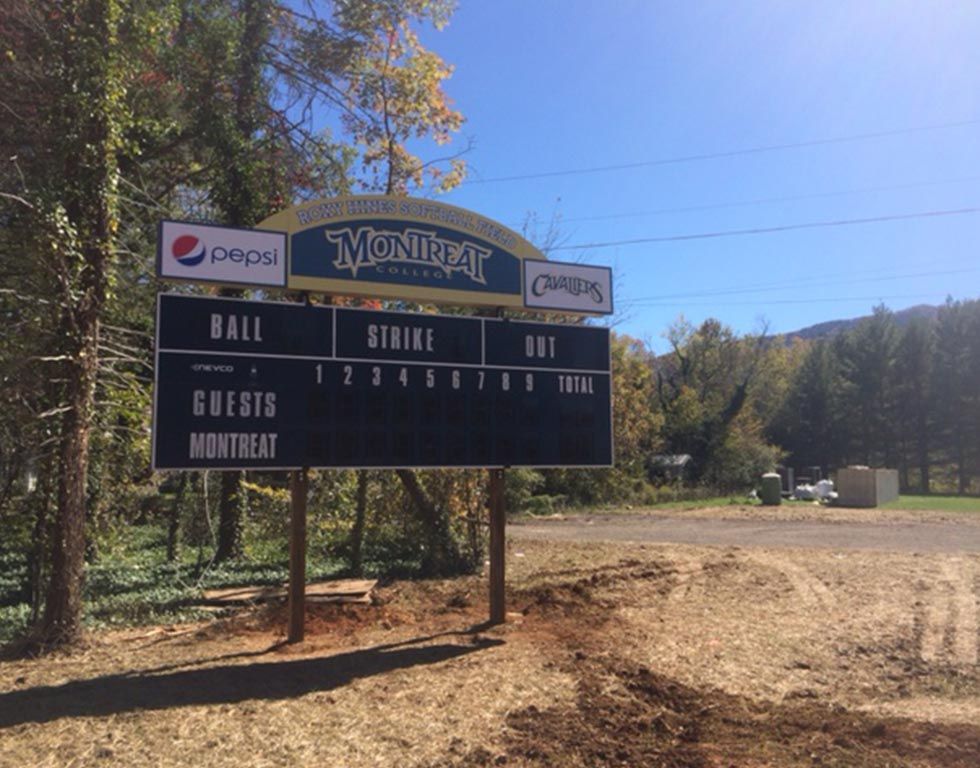 Baseball scoreboard for the Montreat team, advertising Pepsi and Chick-fil-A, on a sunny day in a rural setting.