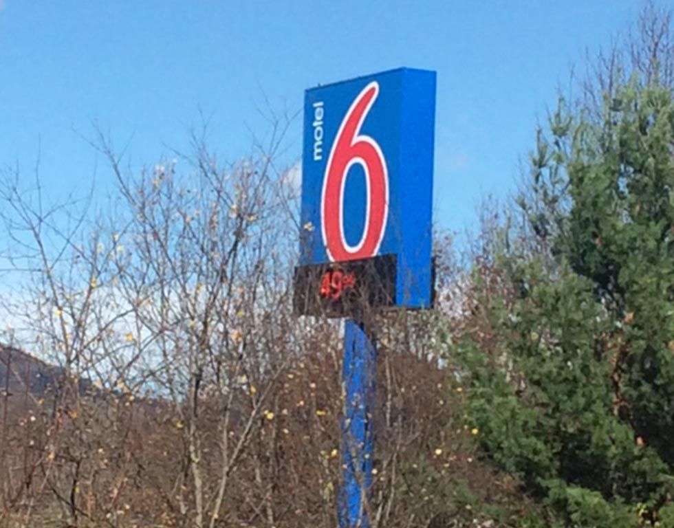 Motel 6 sign with the number 6 in red on a blue background, displaying a digital temperature reading.