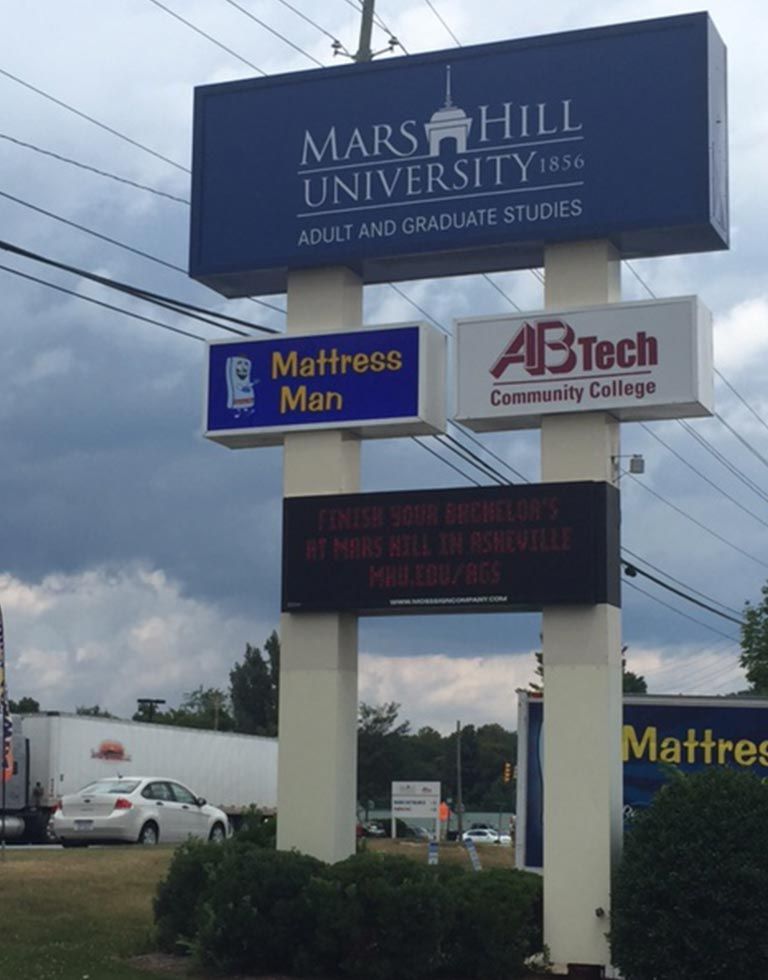 Sign with logos for Mars Hill University, Mattress Man, and AB Tech Community College. Electronic message board displays an advertisement.