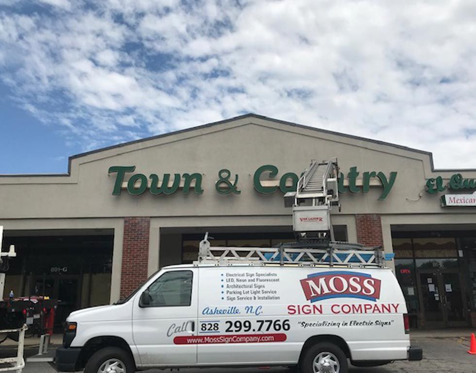 A white van with a lift is parked in front of 