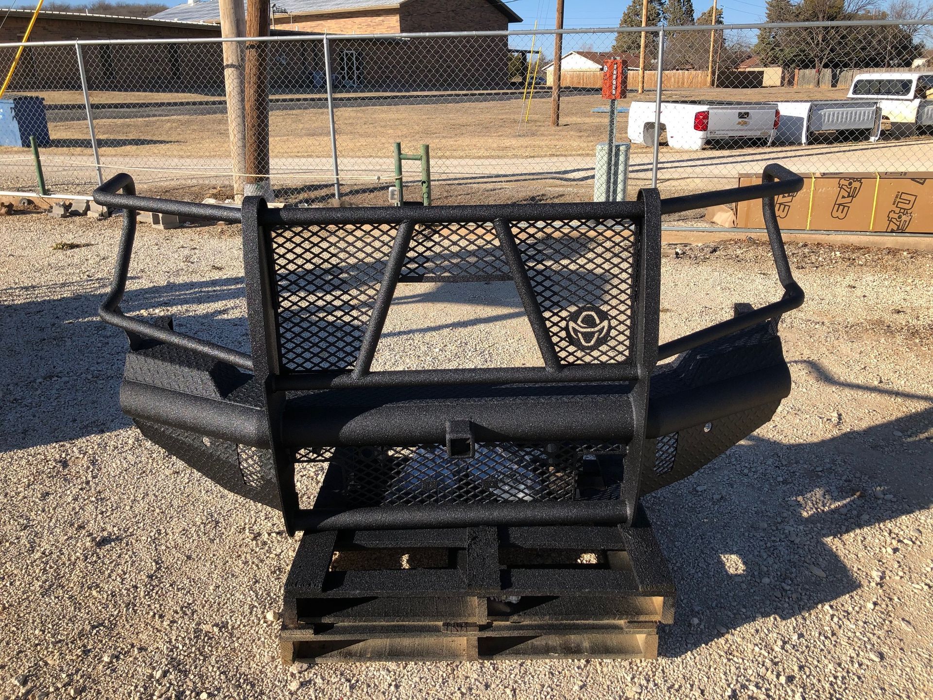 A black bumper is sitting on top of a wooden pallet.