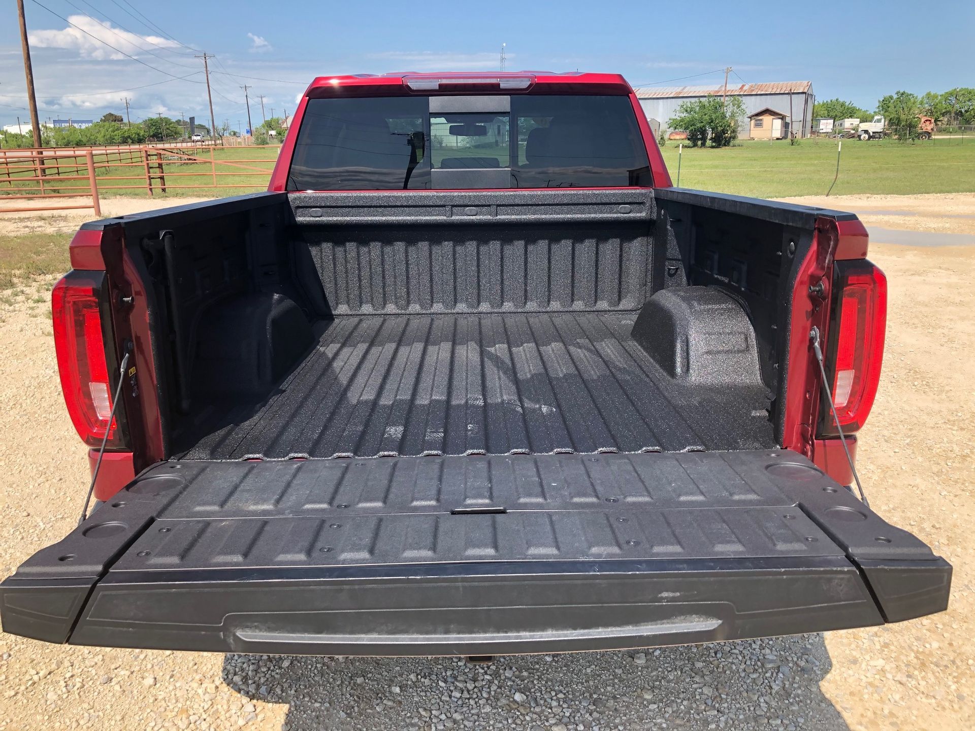 The back of a red truck with the bed open.