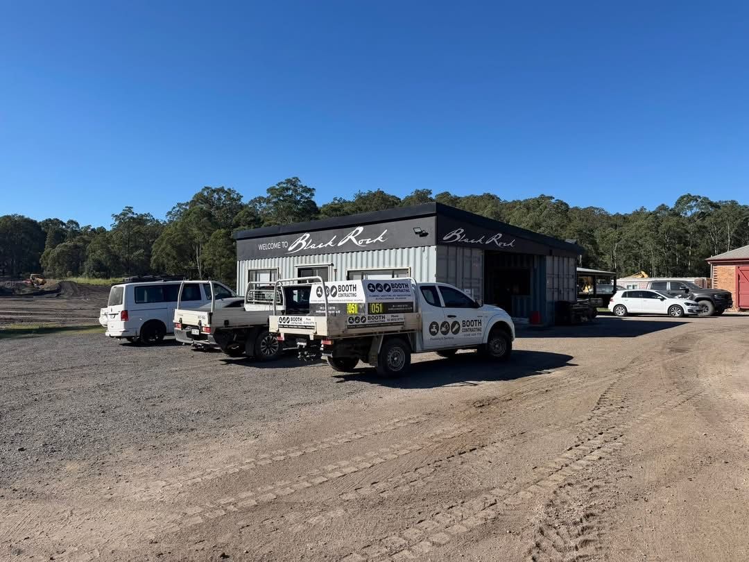 Police cars parked outside a small building on a gravel lot under a clear blue sky