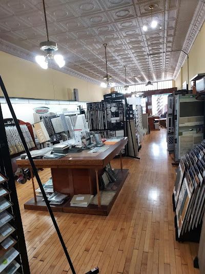 Interior of a flooring store with sample displays, wooden floors, and a decorative ceiling.
