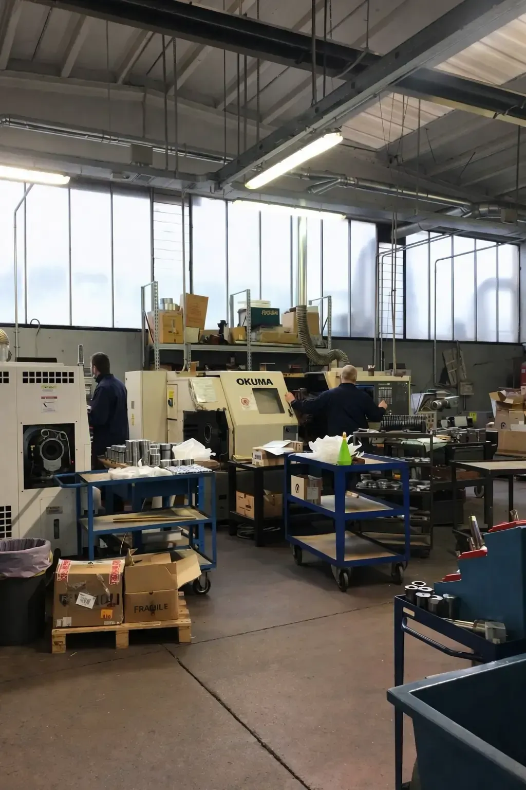 Interno dell'officina con macchinari, operai e utensili.