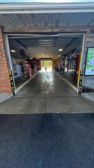 The inside of a car wash with the garage door open.