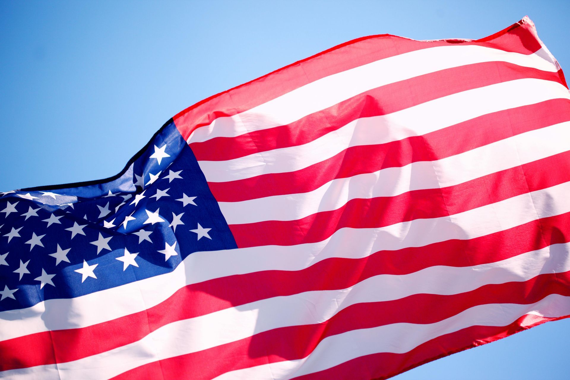 American flag waving against a clear blue sky