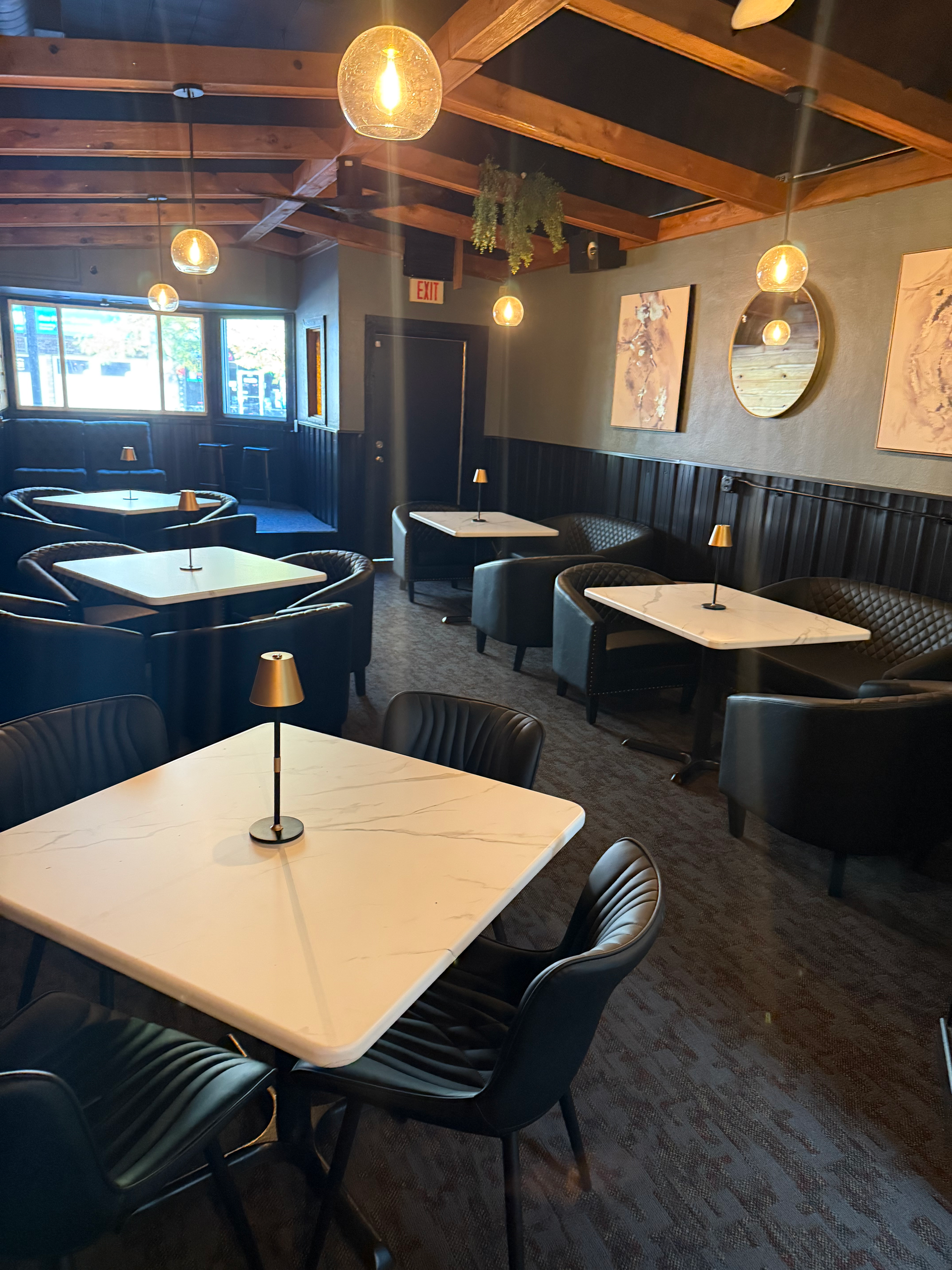 Upscale restaurant interior with booths, tables, and pendant lights.