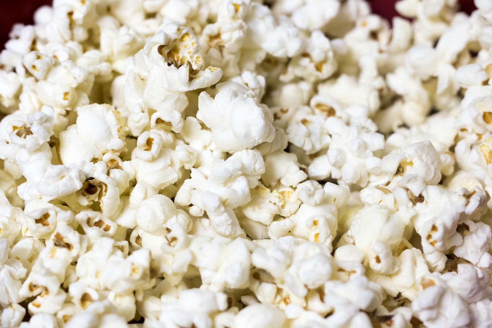 Close-up view of a pile of fluffy, white popcorn. Some kernels show hints of brown.