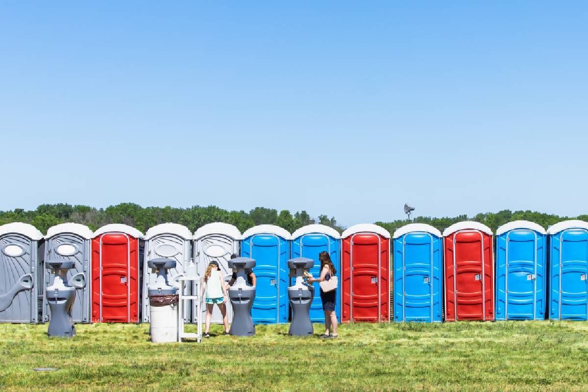 Attendees at an outdoor event using portable washrooms and handwash stations near Lexington, Kentucky (KY) 