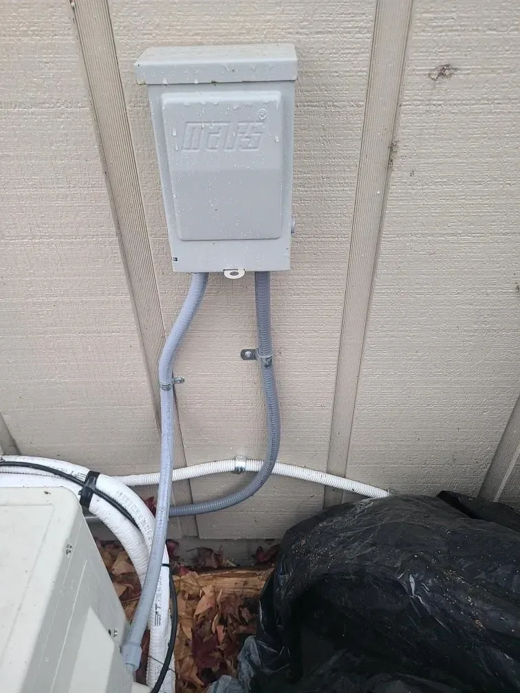 A electrical box is attached to the side of a building.