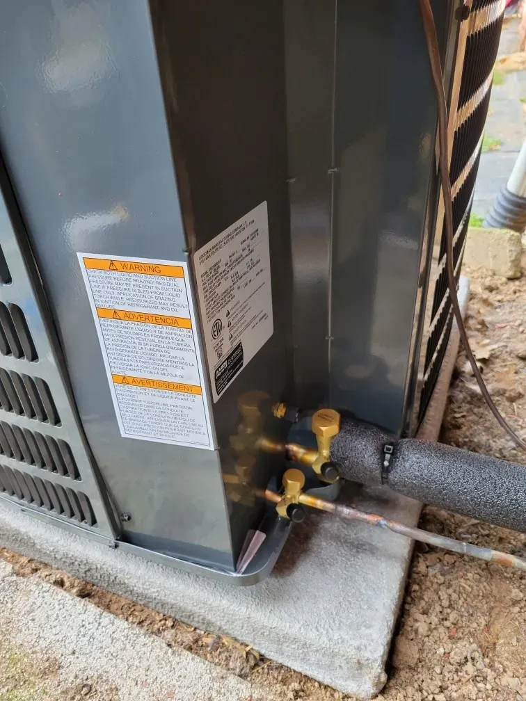 A close up of an air conditioner with a pipe attached to it.