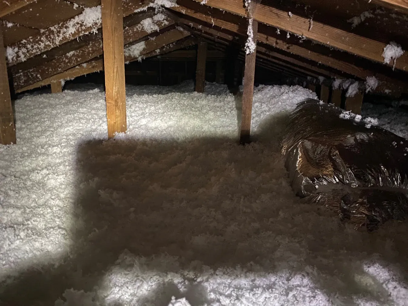 There is a lot of insulation in the attic of a house.