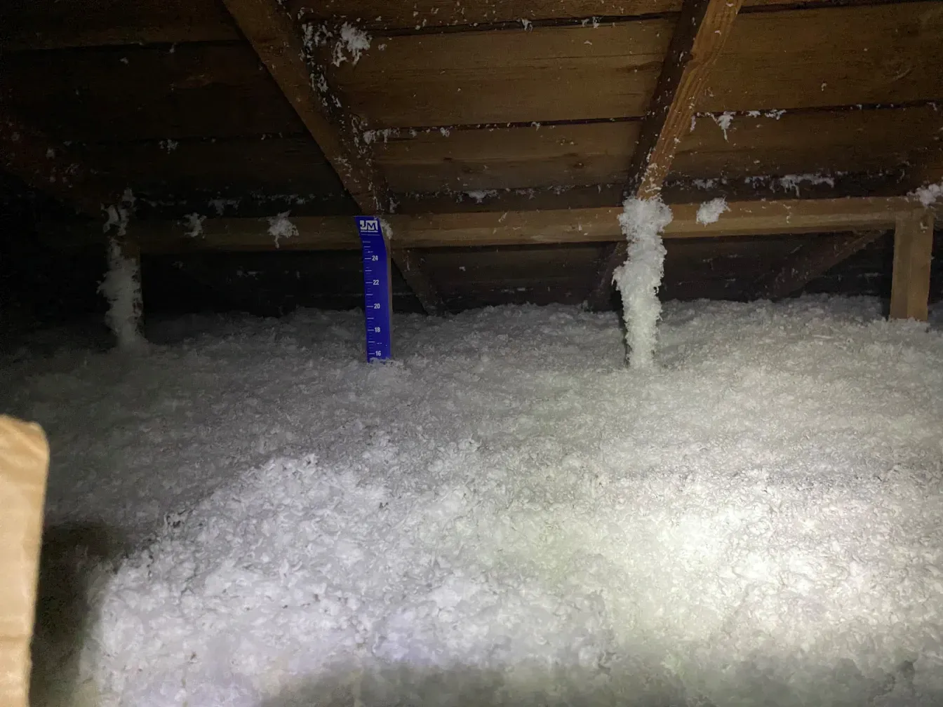 There is a lot of insulation in the attic of a house.