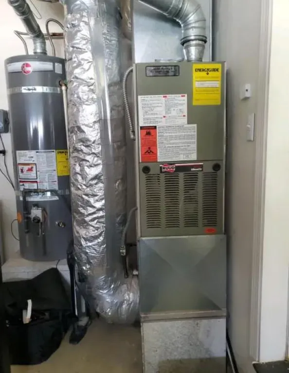 A room with a water heater and an air conditioner