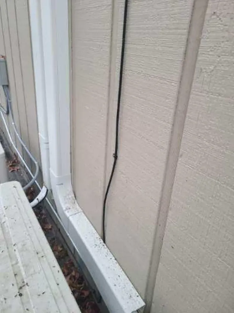 A white gutter is attached to the side of a house.
