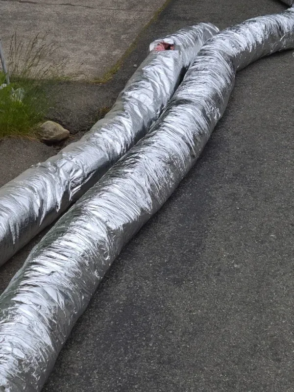 A pair of silver ducts are laying on the ground