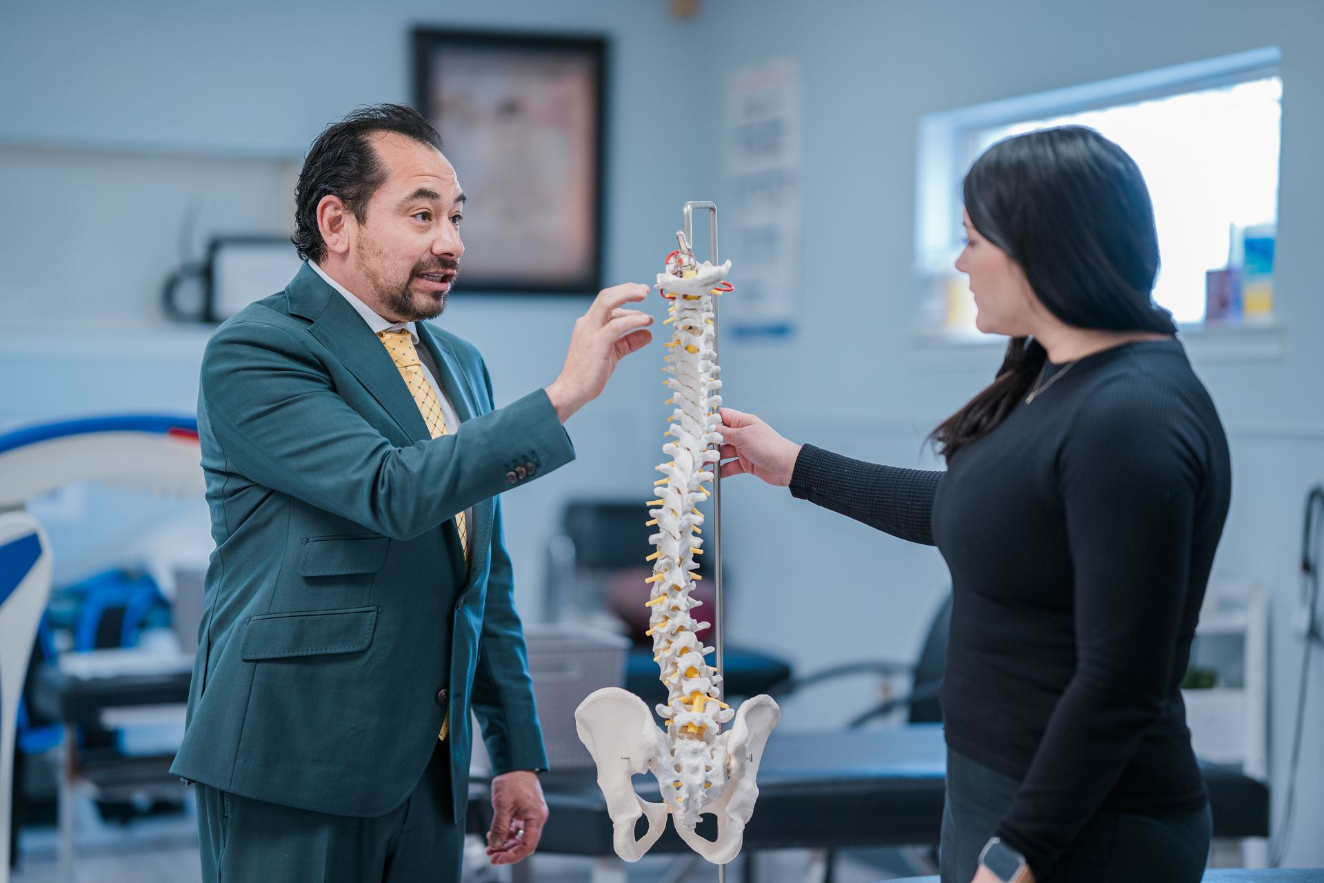 Chiropractor explaining sciatica with a spine model