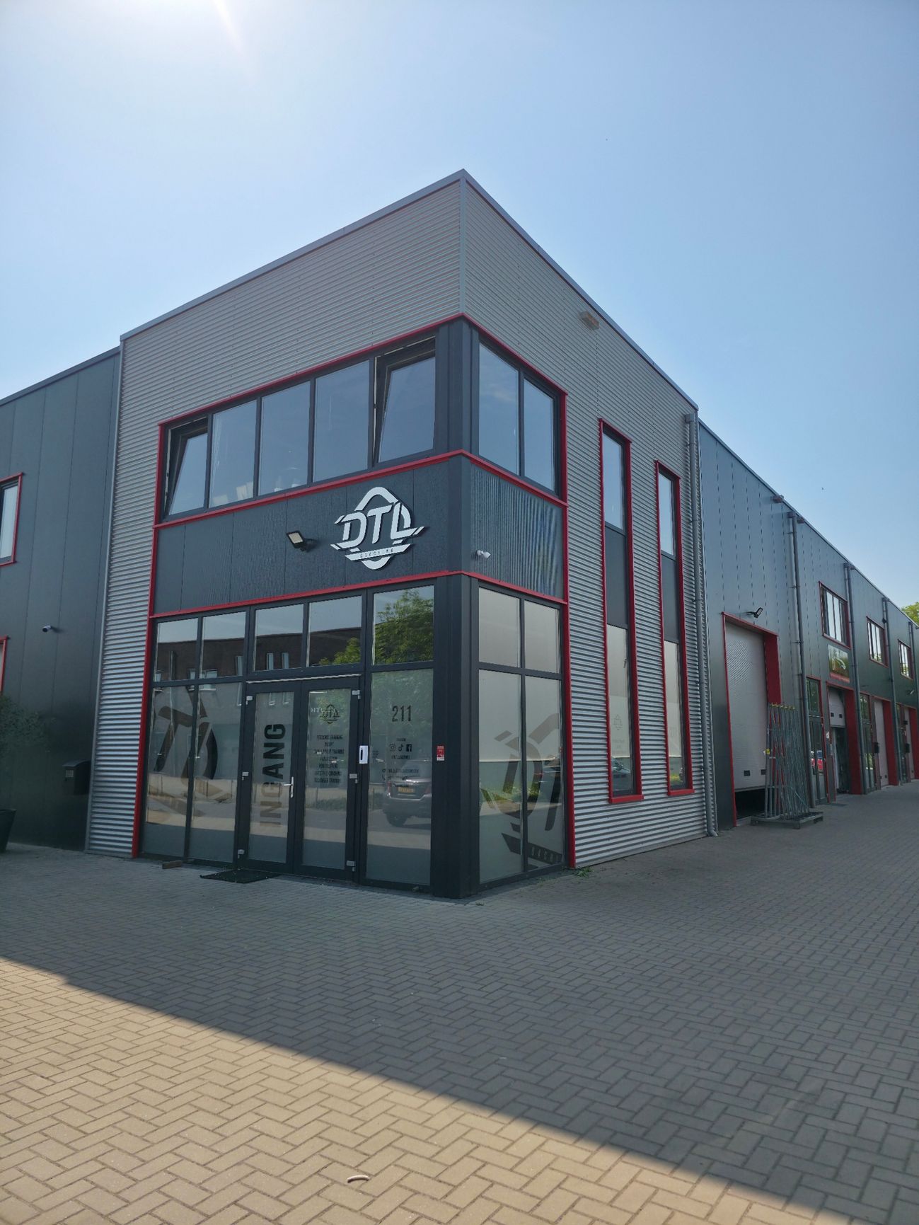 Een groot gebouw met veel ramen staat op een stoep van bakstenen.