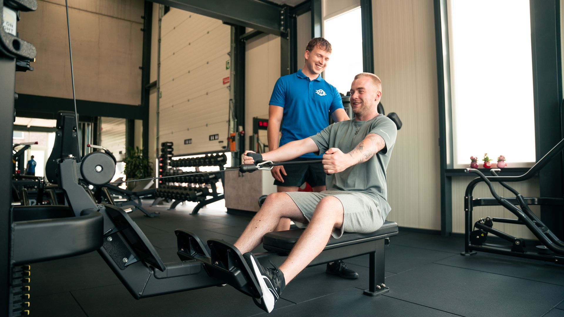 Een man tilt een halter op in een sportschool