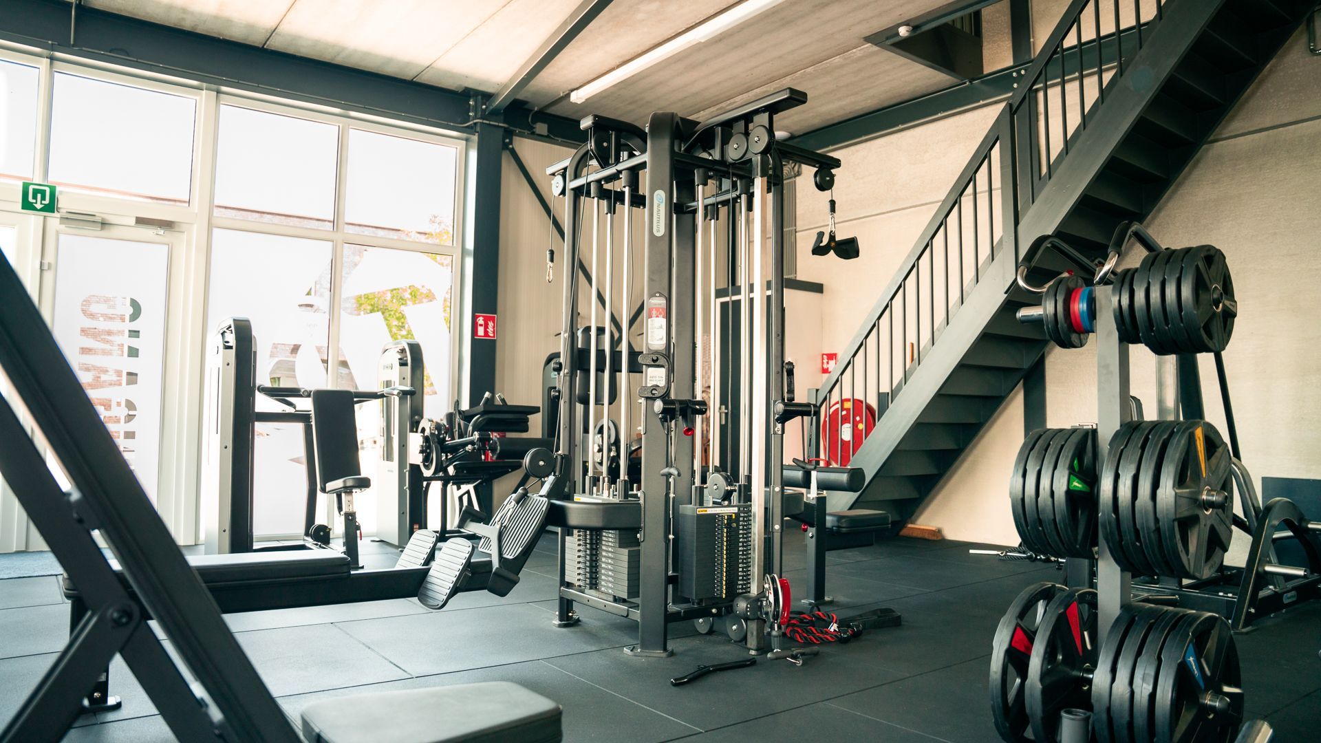 Een sportschool met veel fitnessapparatuur en trappen.