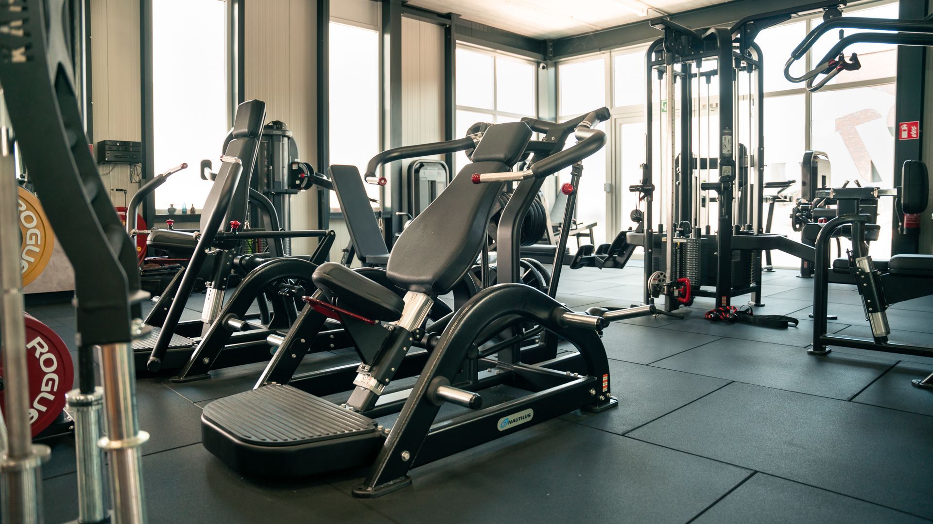 Een sportschool vol met fitnessapparatuur en een loopband.