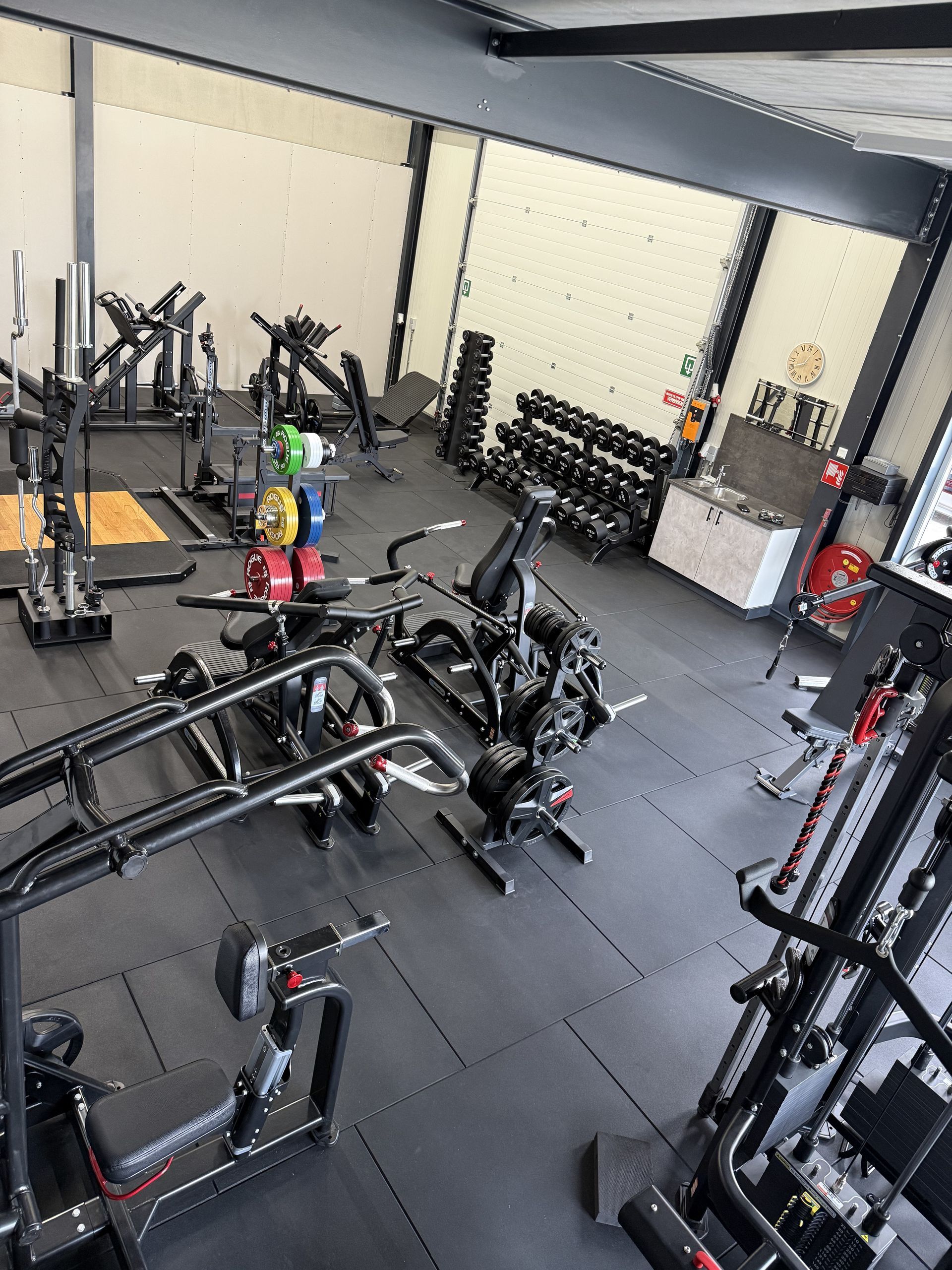 Een grote sportschool vol met fitnessapparatuur.