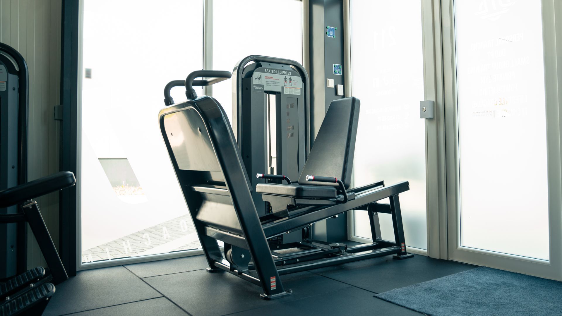 Er staat een machine in een sportschool naast een raam.