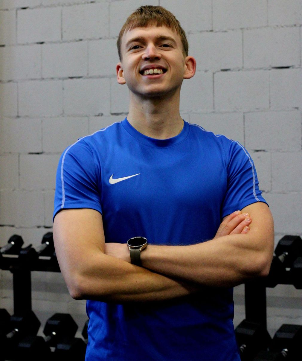 Een man in een blauw Nike-shirt met zijn armen over elkaar