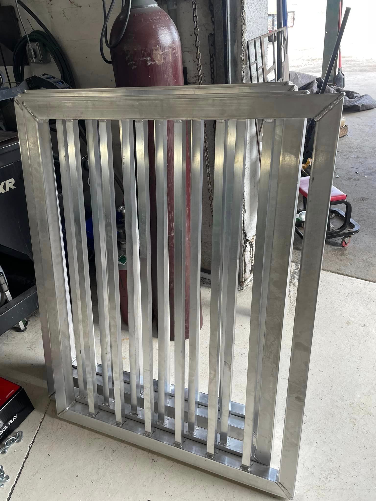 Aluminum frame with vertical bars; likely a gate or screen.