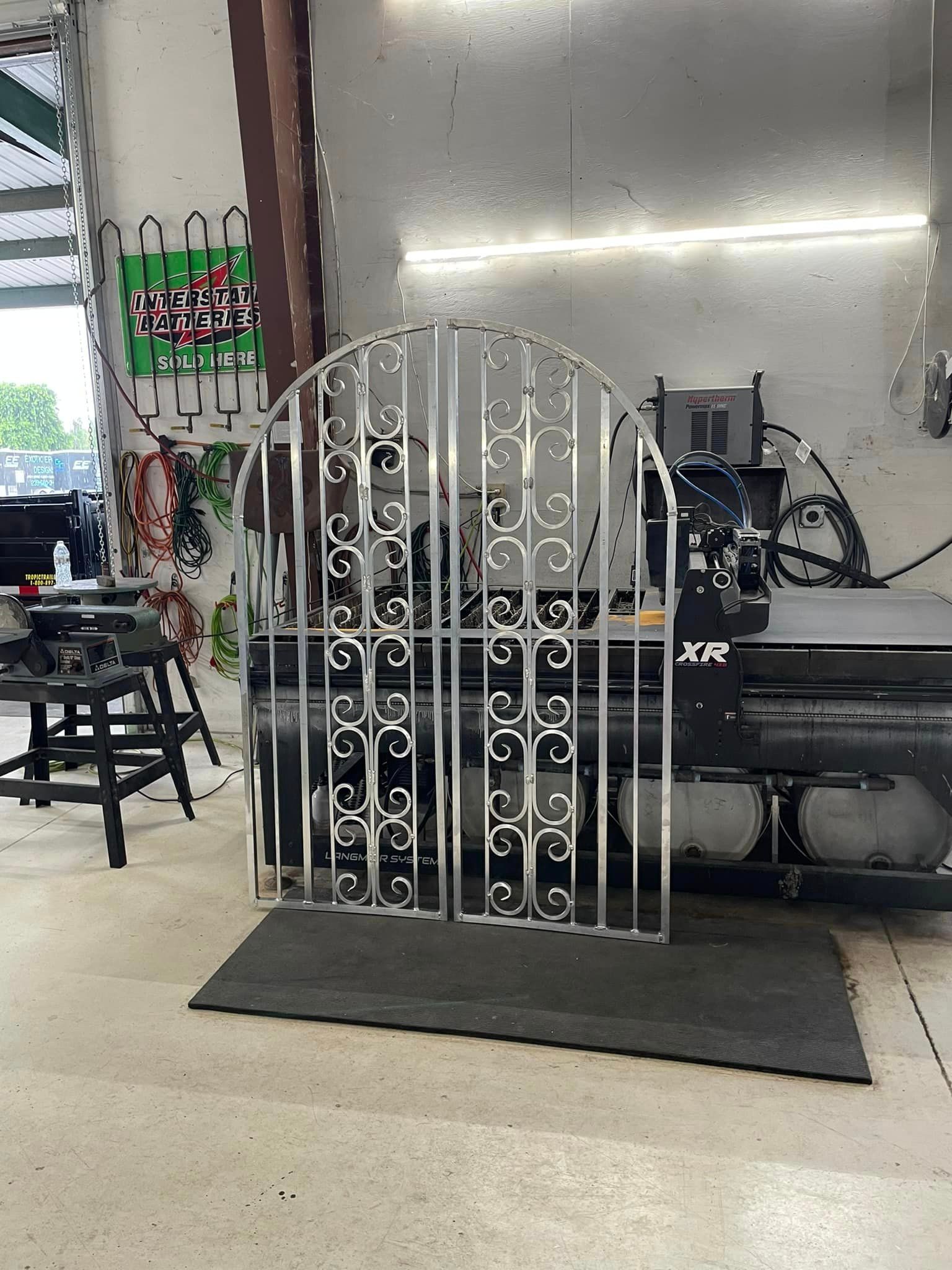 Metal gate with scrollwork design, in a workshop.