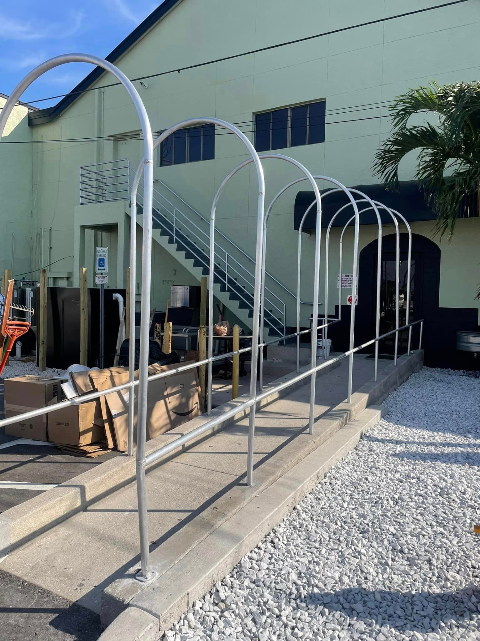 A concrete ramp with metal archways and handrails, leading to a building entrance.