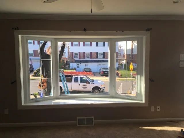 A white truck is parked in front of a large window