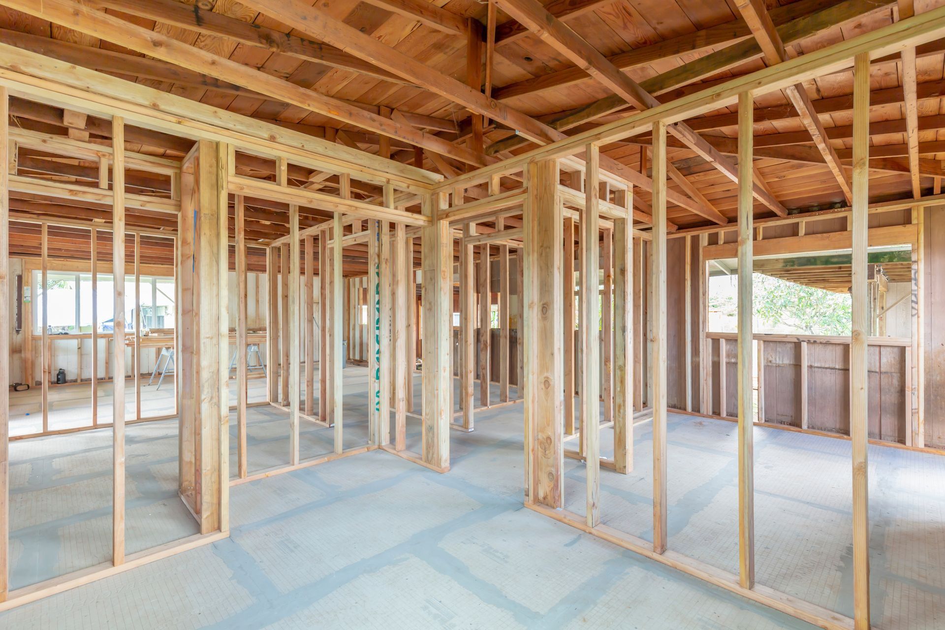 Interior of a house under construction with exposed wooden framing and unfinished floors
