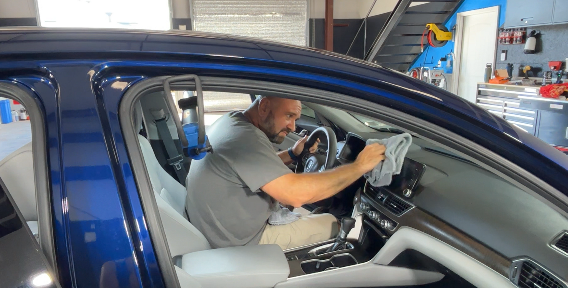 Black sports car with reflections of clouds and sky.