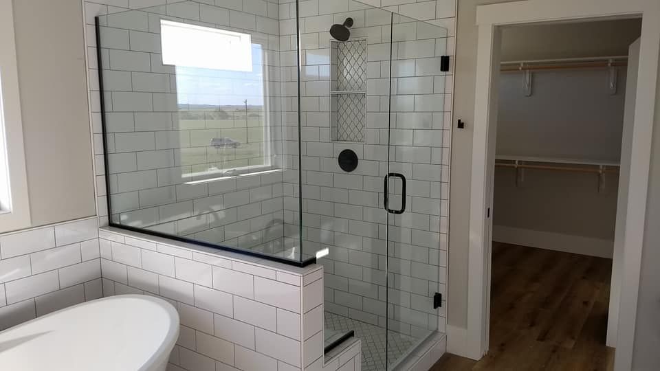 Bathroom with glass shower, white subway tile, and a walk-in closet with wood shelving.