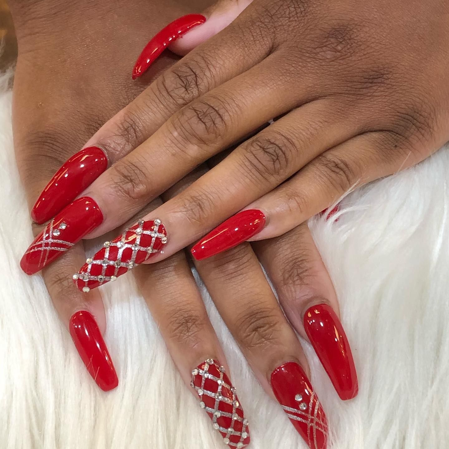 A close up of a woman 's hand with long red nails