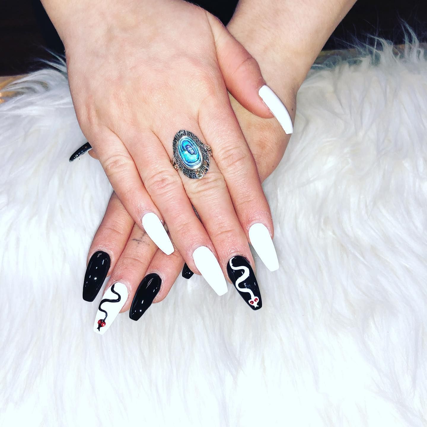 A woman 's hand with long nails and a ring on her finger