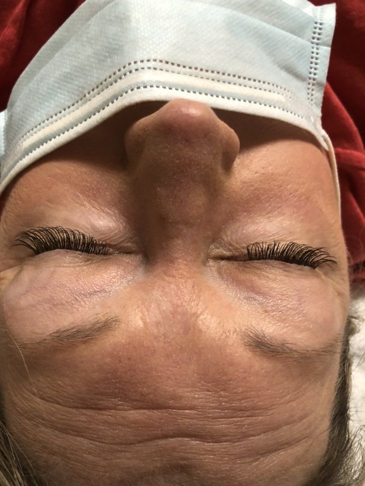 A woman wearing a face mask with her eyes closed.