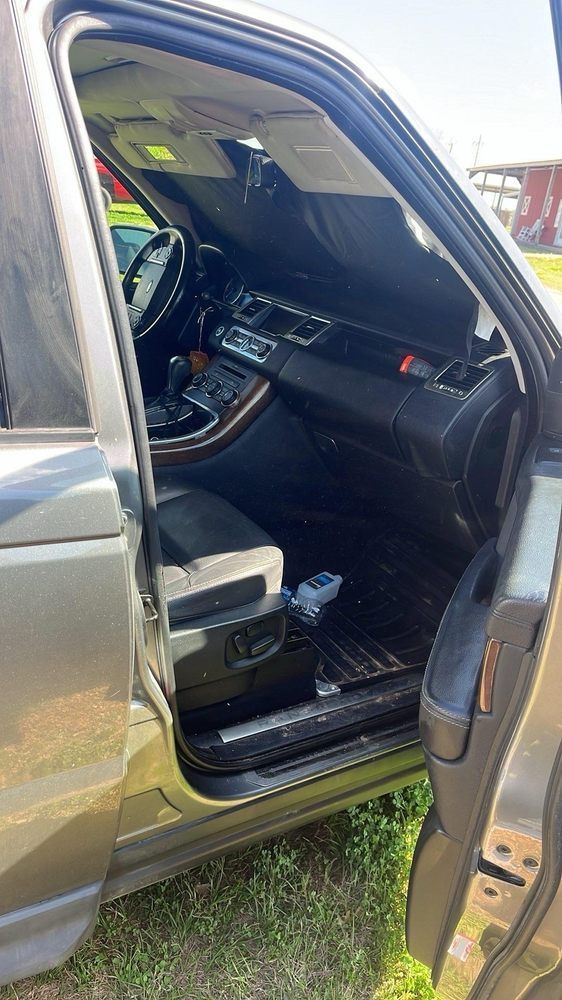 Open car door reveals interior of a grey Range Rover.